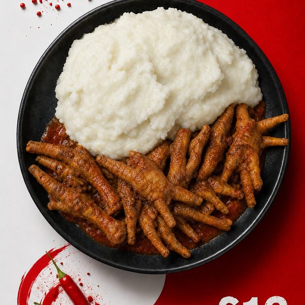 Spiced chicken feet in rich tomato sauce served with sadza and greens